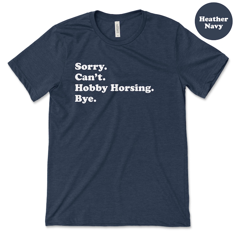 May include: A heather navy blue t-shirt with the text "Sorry. Can't. Hobby Horsing. Bye." printed in white.