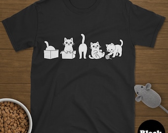 May include: Black t-shirt featuring a playful white cat graphic. The design shows four cats in different poses: one in a box, one looking out of a box, one with its rear end up, one sitting, and one playing with yarn. The word "Black" is in a black circle.