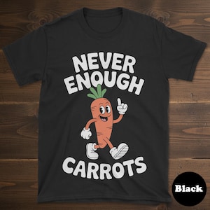 May include: Black t-shirt with the text "NEVER ENOUGH CARROTS" in white. A cartoon carrot character with a smiling face, arms, and legs is running and pointing upwards. The shirt is made of a soft material.