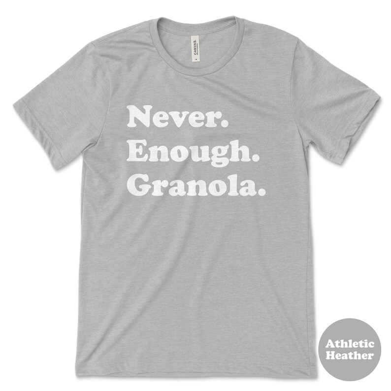 May include: A heather grey t-shirt with the text "Never. Enough. Granola." printed in white.