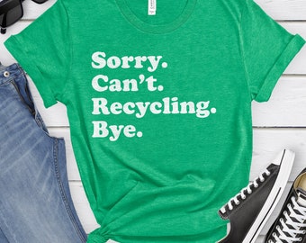 Può includere: Una maglietta verde con il testo "Sorry. Can't. Recycling. Bye." in bianco.