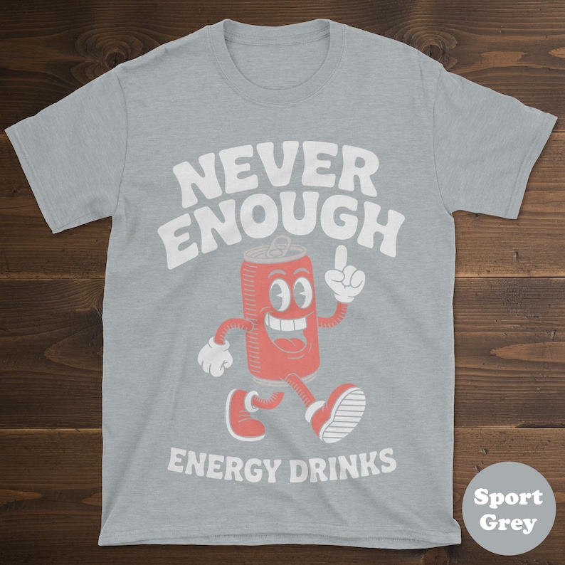 May include: Sport grey t-shirt with the words "NEVER ENOUGH ENERGY DRINKS" in white. A cartoon energy drink can character is featured in red with white accents, pointing upwards.