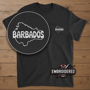 May include: Black t-shirt with an embroidered outline of Barbados and the word "BARBADOS" in white. A smaller embroidered version of the design is on the upper chest. The word "EMBROIDERED" is below the shirt.