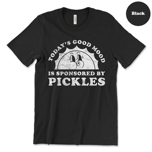 May include: Black t-shirt with a white graphic of a smiling sun with the text "Today's Good Mood Is Sponsored By Pickles".