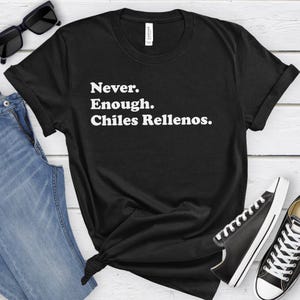 May include: Black t-shirt with white text that reads "Never. Enough. Chiles Rellenos."