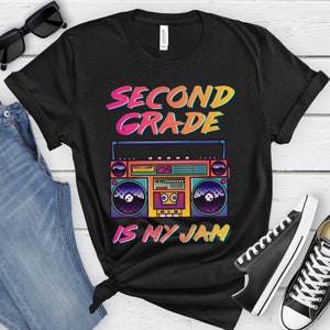 May include: Black t-shirt with a colorful retro boombox graphic and the text "Second Grade is My Jam".