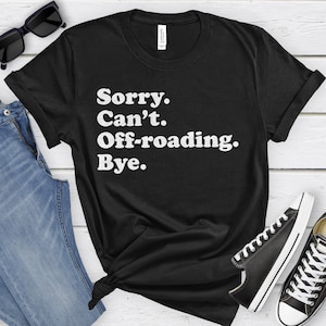 May include: Black t-shirt with white text that reads "Sorry. Can't. Off-roading. Bye."