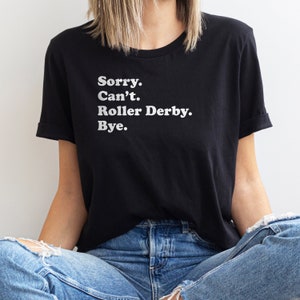 K&ouml;nnte beinhalten: Ein schwarzes T-Shirt mit wei&szlig;em Text, der "Sorry. Can't. Roller Derby. Bye." lautet.