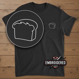 May include: Black t-shirt with a white embroidered bread loaf design on the chest and a larger detailed view in a circle. The word "EMBROIDERED" is displayed below the shirt.