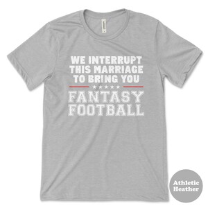 May include: Grey t-shirt with the text "We interrupt this marriage to bring you Fantasy Football" in white letters with a red line above and below the text.