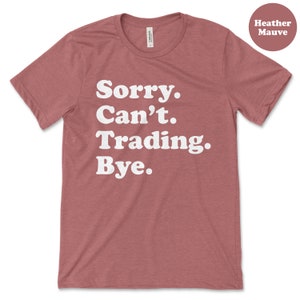 May include: Heather mauve t-shirt with white text that reads "Sorry. Can't. Trading. Bye."