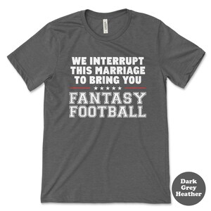 May include: Dark grey heather t-shirt with the text "We interrupt this marriage to bring you Fantasy Football" in white with red stars.