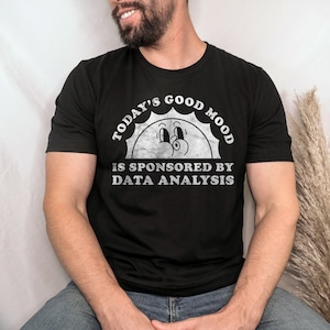 May include: A black t-shirt with a white graphic of a smiling sun with the text "Today's Good Mood Is Sponsored By Data Analysis".