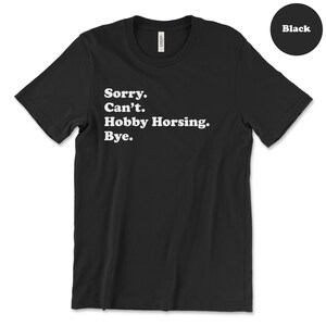 May include: Black t-shirt with the text "Sorry. Can't. Hobby Horsing. Bye."