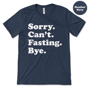 May include: A heather navy blue t-shirt with the text "Sorry. Can't. Fasting. Bye." printed in white.