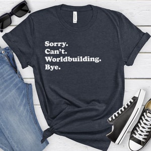 May include: A dark blue t-shirt with white text that reads "Sorry. Can't. Worldbuilding. Bye."