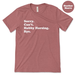 May include: Heather mauve t-shirt with the text "Sorry. Can't. Hobby Horsing. Bye."