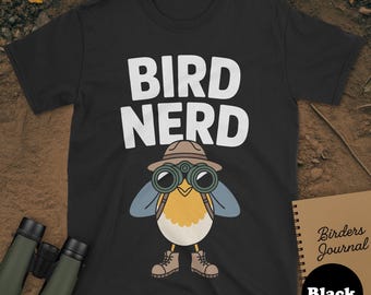 May include: Black t-shirt with the words "BIRD NERD" in white. The shirt features a cartoon bird wearing a hat and binoculars. A notebook with the words "Birders Journal" is visible.