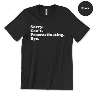 May include: Black t-shirt with white text that reads "Sorry. Can't. Procrastinating. Bye."