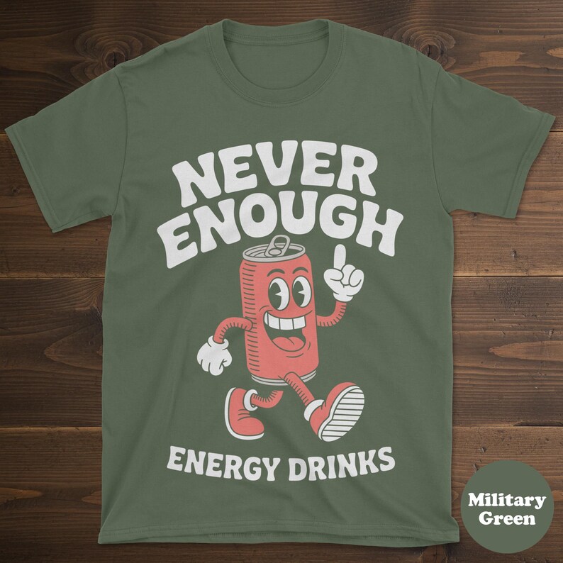 May include: Military green t-shirt with the text "NEVER ENOUGH ENERGY DRINKS" in white. The design features a cartoon energy drink can with a smiling face, arms, and legs, pointing upwards.