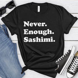 May include: Black t-shirt with white text that reads "Never. Enough. Sashimi."