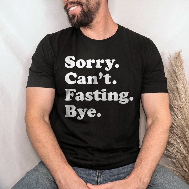 May include: A black t-shirt with the text "Sorry. Can't. Fasting. Bye." printed in white.