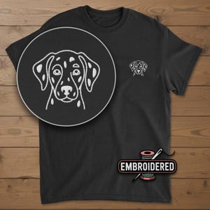 May include: Black t-shirt with a white embroidered Dalmatian dog design. The shirt features a small embroidered dog on the chest and a larger detailed image in a circle. The word "EMBROIDERED" is also in the image.