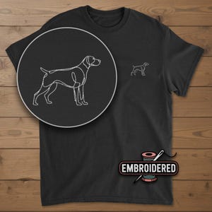 May include: Black t-shirt with a white embroidered outline of a dog on the chest and a larger, detailed version in a circular inset. The word "EMBROIDERED" is printed on a pink spool of thread.