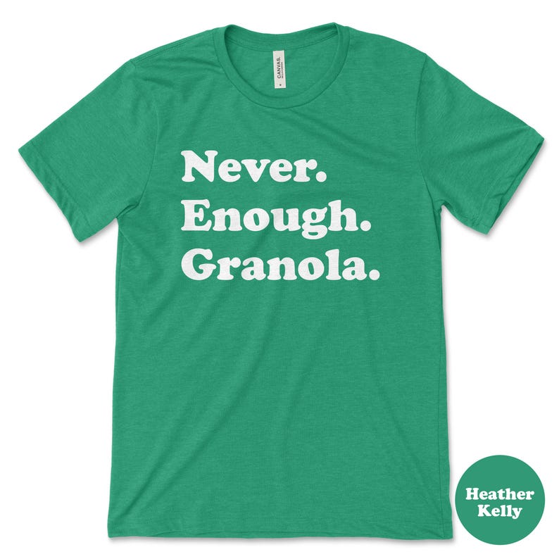 May include: Green t-shirt with white text that reads "Never. Enough. Granola."