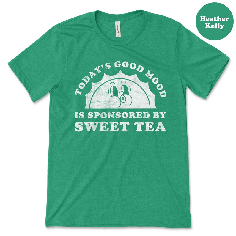 May include: Green t-shirt with a white distressed graphic that says "Today's Good Mood Is Sponsored By Sweet Tea" with a cartoon sun face.