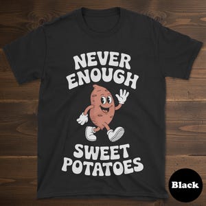 May include: Black t-shirt with the text "NEVER ENOUGH SWEET POTATOES" in white. A cartoon sweet potato character with a smiling face, white gloves, and shoes is featured in the center of the shirt.