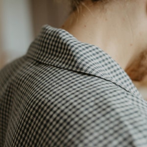 May include: Close-up of a black and white gingham shirt collar. The fabric is soft and textured.