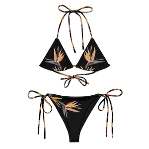 May include: Black bikini with a tropical bird print. The top is a triangle style with adjustable straps and the bottom is a cheeky style with ties on the sides.