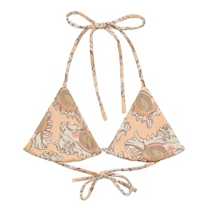 May include: A peach-colored triangle bikini top with a seashell print. The top has adjustable straps and ties at the back.