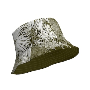 Può includere: Un cappello a secchiello verde con una stampa di palme bianche. Il cappello ha un'ampia tesa e una corona piatta.