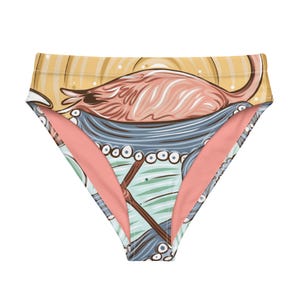 May include: High-waisted bikini bottoms with a pink flamingo and blue ocean wave print. The fabric is a soft, peachy pink color.