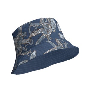 Può includere: Un cappello a secchiello blu con un motivo di illustrazioni di polpi bianchi e grigi.