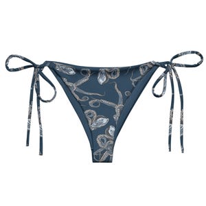Puede incluir: Braga de bikini azul con un diseño de nudo lateral y un estampado de pulpo.