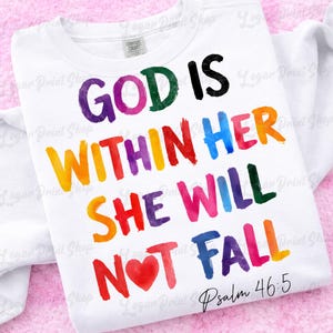 Op de afbeelding: Wit T-shirt met de tekst "GOD IS WITHIN HER SHE WILL NOT FALL" in diverse kleuren. De tekst is in handschriftstijl, met "Psalm 46:5" eronder. Het shirt heeft een ronde hals.