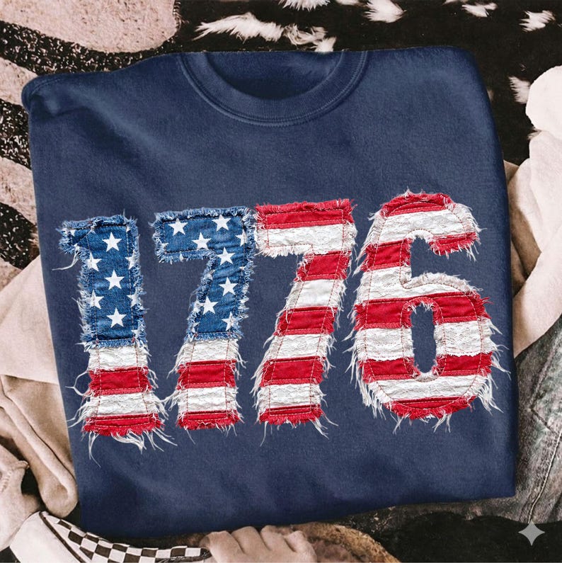 May include: Navy blue sweatshirt featuring the number "1776" in a distressed American flag design. The numbers are made of red and white stripes and blue fields with white stars, giving a patriotic look.