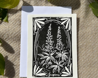 Peut inclure: Gravure sur linoléum en noir et blanc d'une fleur de lupin avec le mot "Lupine" écrit sous l'image.