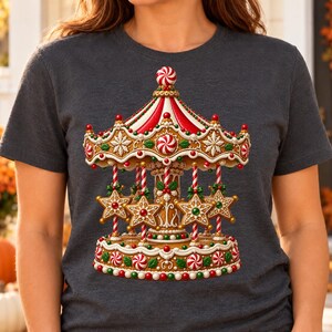 May include: A dark heather gray t-shirt featuring a graphic print of a gingerbread carousel. The carousel is decorated with red and white peppermint swirls, green holly leaves, and star-shaped gingerbread cookies hanging from striped poles.