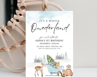 May include: A blue and white watercolor invitation for a winter wonderland themed first birthday party. The invitation features a deer, fox, squirrel, and bear pulling a blue sled with a Christmas tree. The text on the invitation reads "It's a Winter Onederland" and "Join us to celebrate Aspen's 1st Birthday, December 9 | 12:00 PM, 123 Main Street, Boston, MA, RSVP to 098.765.4321 by 11/25."