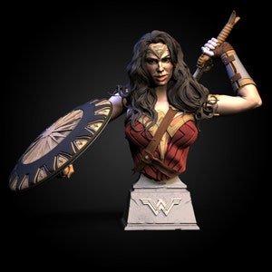 Può includere: Un busto di Wonder Woman, una supereroina, che tiene una spada e uno scudo. Indossa un costume rosso e oro con una stella sulla fronte. Il busto è su una base di pietra con la lettera "W" su di essa.