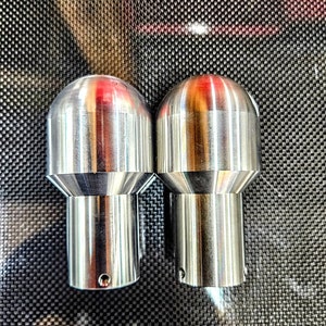 May include: Two silver metal bottle stoppers with a rounded top and a threaded base.