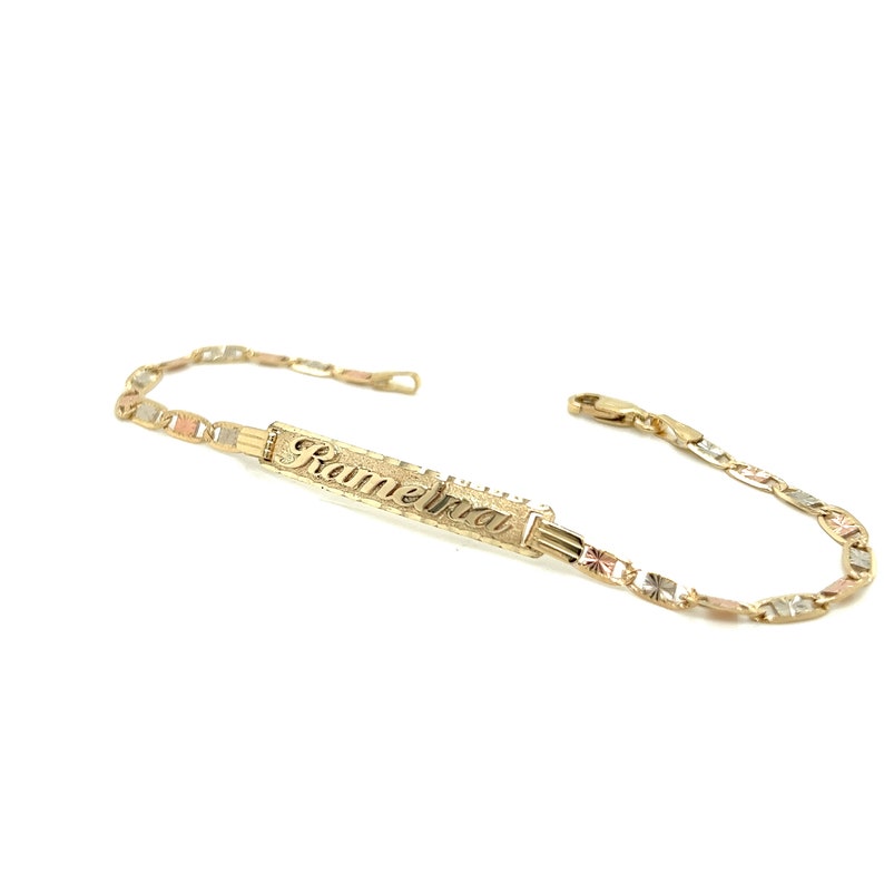 May include: A gold bracelet with a nameplate that reads "Kamelia". The bracelet is made of three different colors of gold: yellow, white, and rose.