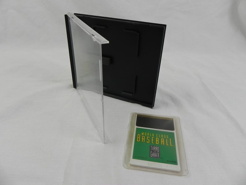 May include: A clear plastic game case with a black backing and a video game cartridge. The cartridge has a green and white label that reads "WORLD CLASS BASEBALL TURBO GRAFX". The case is open and the cartridge is in a clear plastic sleeve.