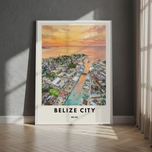 May include: A rectangular wall art print featuring an aerial view of Belize City at sunset. The image displays a coastal urban landscape with a central waterway, boats, and buildings under a warm orange and pink sky. The text BELIZE CITY BELIZE is printed in black at the bottom.