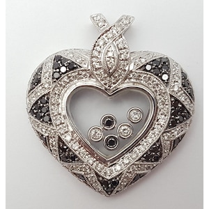 May include: A heart-shaped pendant with a clear center containing small, round gems. The pendant is encrusted with black and white gemstones, with a decorative bail at the top. The overall design is intricate and detailed.