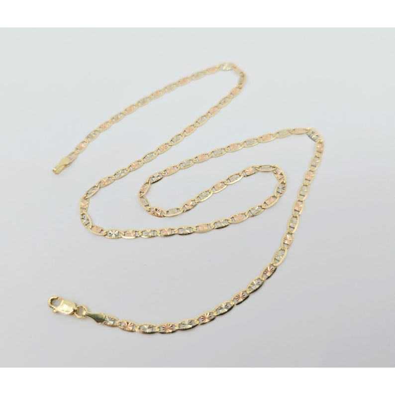 May include: A delicate gold necklace with a lobster clasp. The chain features a repeating pattern of oval and star-shaped links in gold, rose gold, and yellow gold. The necklace is displayed on a white background.